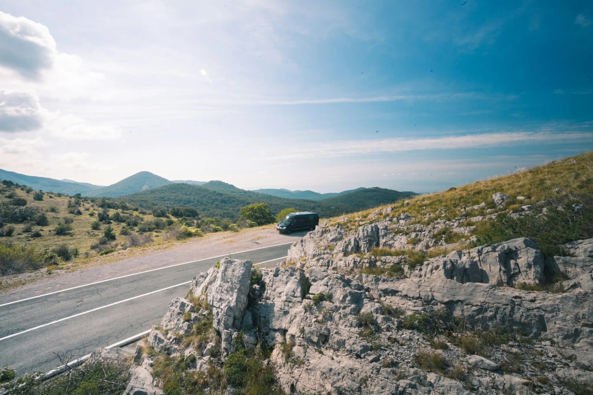 Furgoneta circulando por una carretera de montaña de piedra caliza